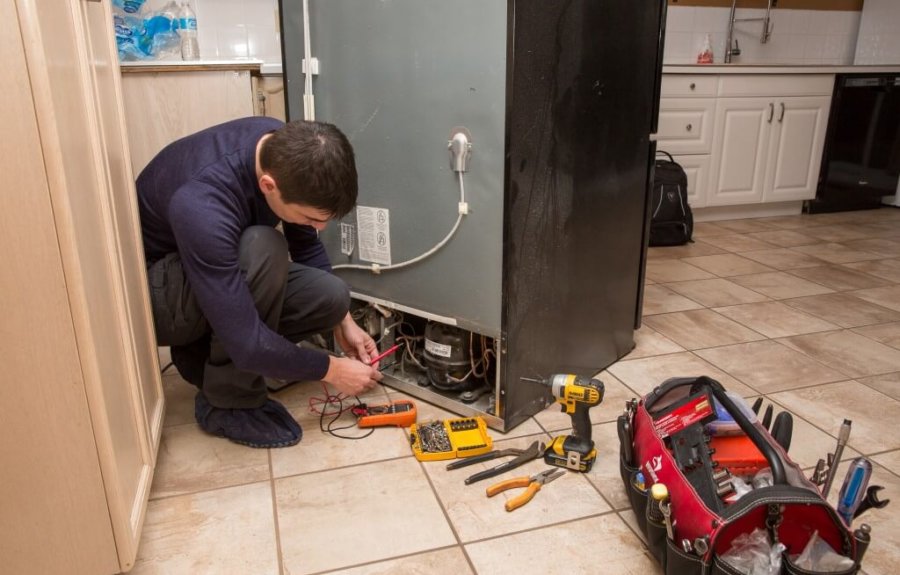 Srinivas Enterprises technician repairing a refrigerator